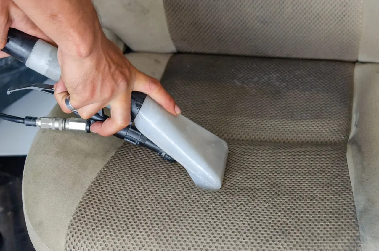 Fabric car seat cleaned with an extraction tool